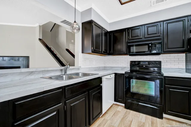 a kitchen with stainless steel appliances kitchen island a stove and a sink