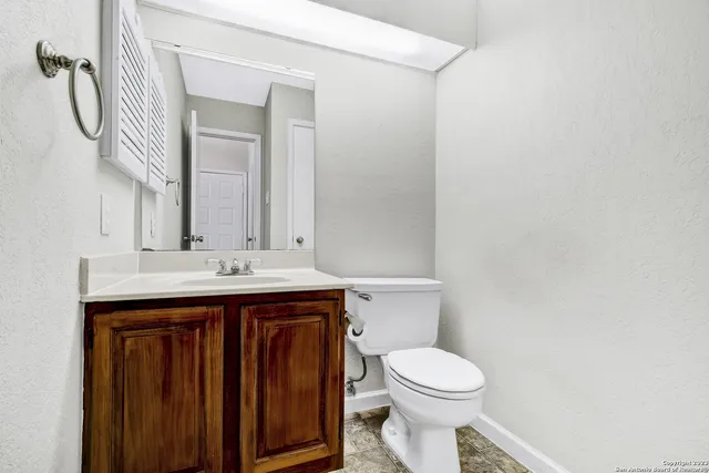 a bathroom with a sink a toilet and mirror
