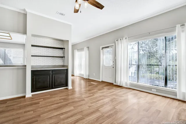 wooden floor fireplace and windows in an empty room