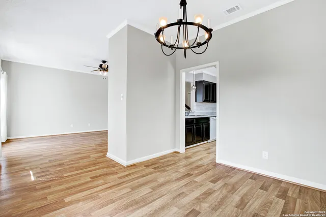 a view of a livingroom with wooden floor and a chandelier
