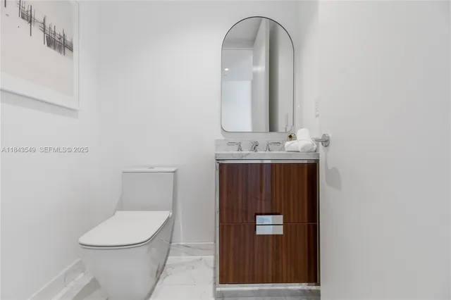 a bathroom with a toilet a sink and mirror