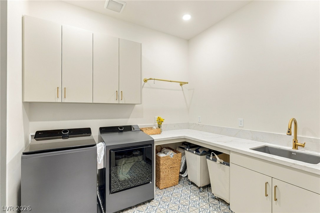324 Wanda Road Henderson, NV 89002 - Photo 57 of 96 A modern utility space features patterned tile flooring, stone countertops, and extensive cabinetry.
