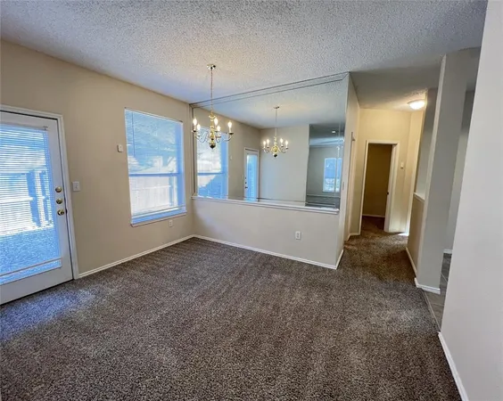 an empty room with a bathroom and windows