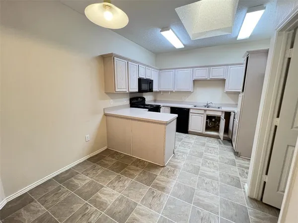a kitchen with a sink a stove and cabinets