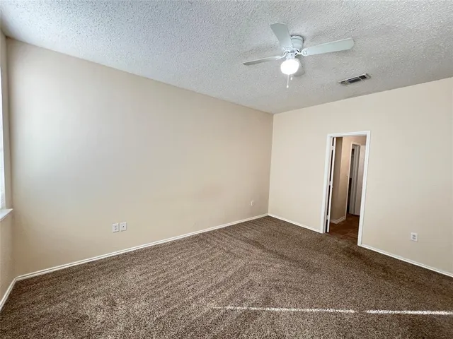 an empty room with closet and a ceiling fan