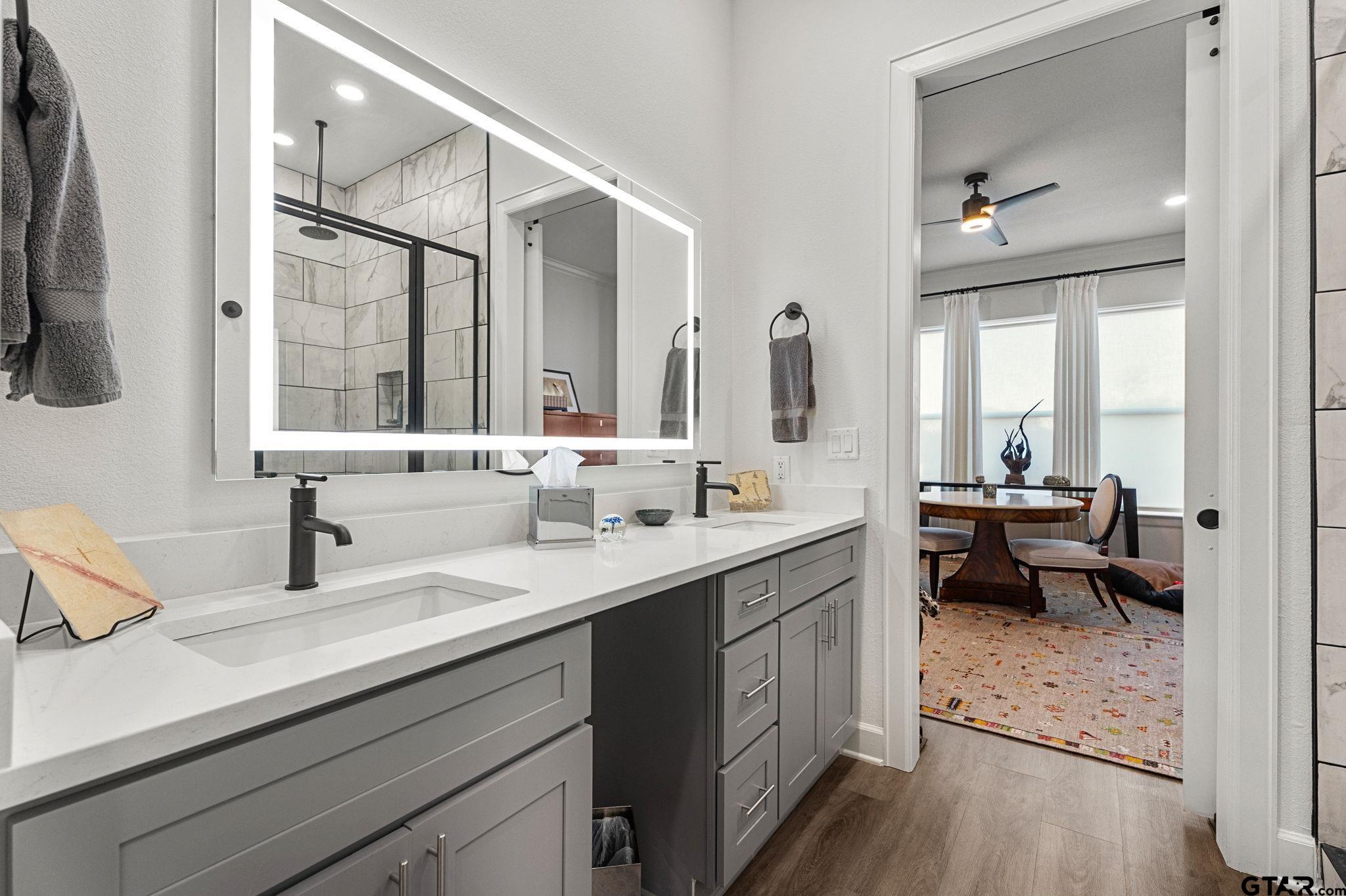 546 West Erwin Street Tyler, TX 75702 - Photo 21 of 31 a en suite bathroom with a double vanity sink a mirror and a bathtub
