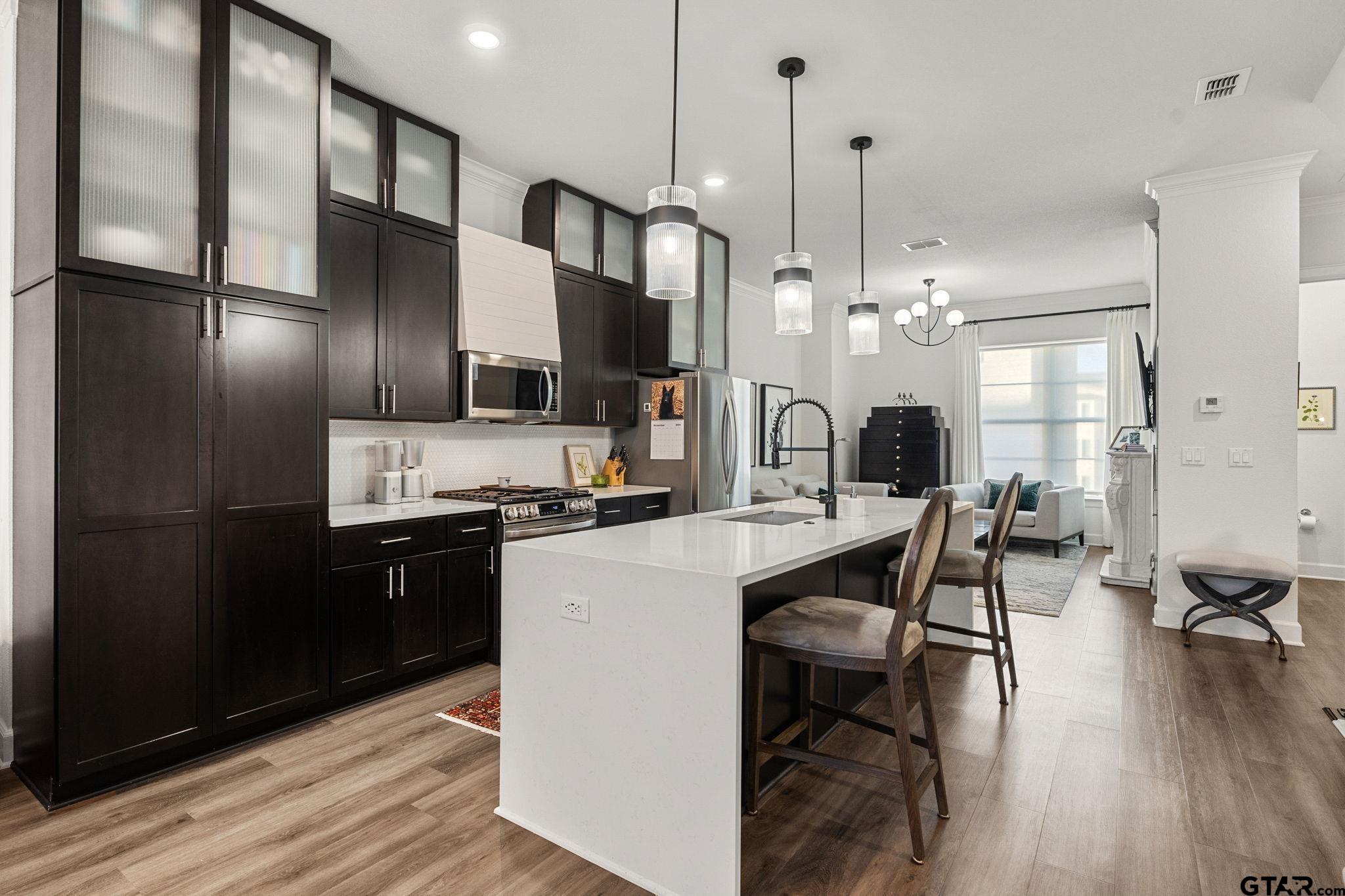 546 West Erwin Street Tyler, TX 75702 - Photo 10 of 31 a kitchen with stainless steel appliances granite countertop a sink refrigerator and cabinets