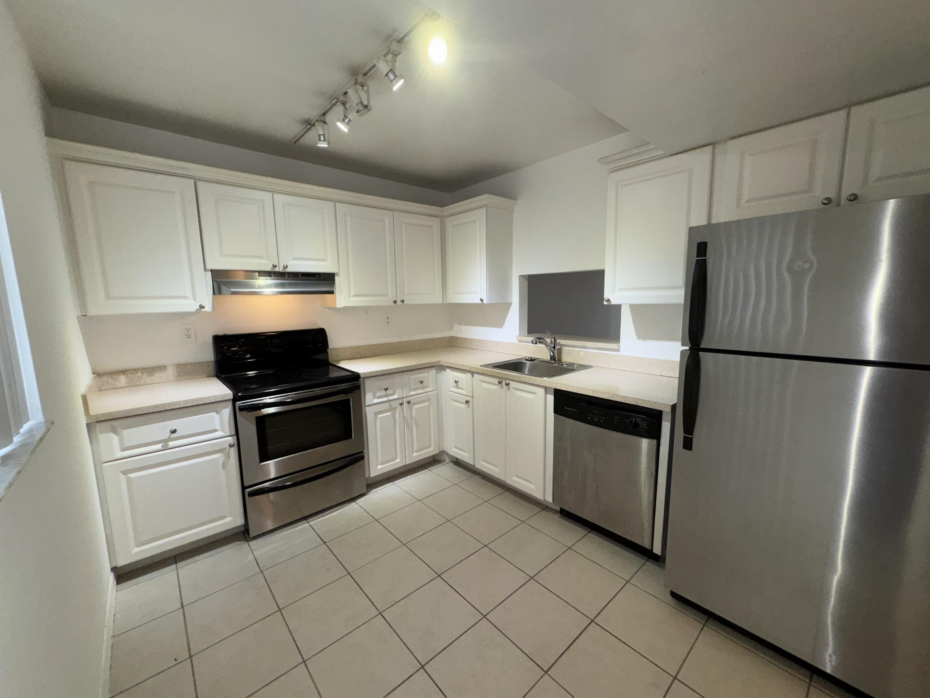 701 North Pine Island Road, Unit 105 Plantation, FL 33324 - Photo 2 of 23 a kitchen with white cabinets and white appliances