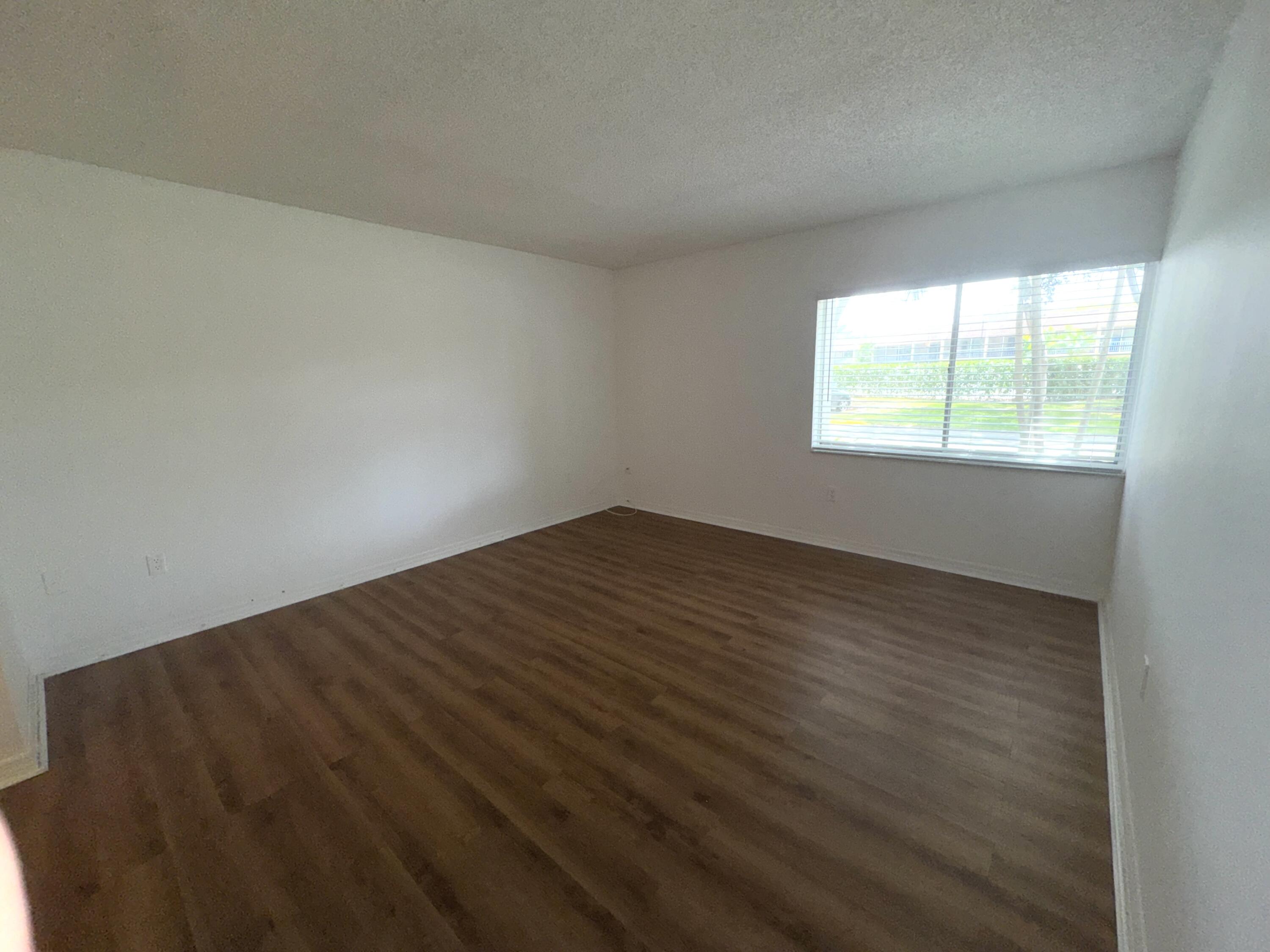 701 North Pine Island Road, Unit 105 Plantation, FL 33324 - Photo 4 of 23 an empty room with wooden floor and windows