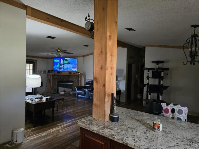 a room with lots of wooden furniture and kitchen view