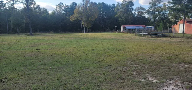 a backyard of a house with lots of green space and chair