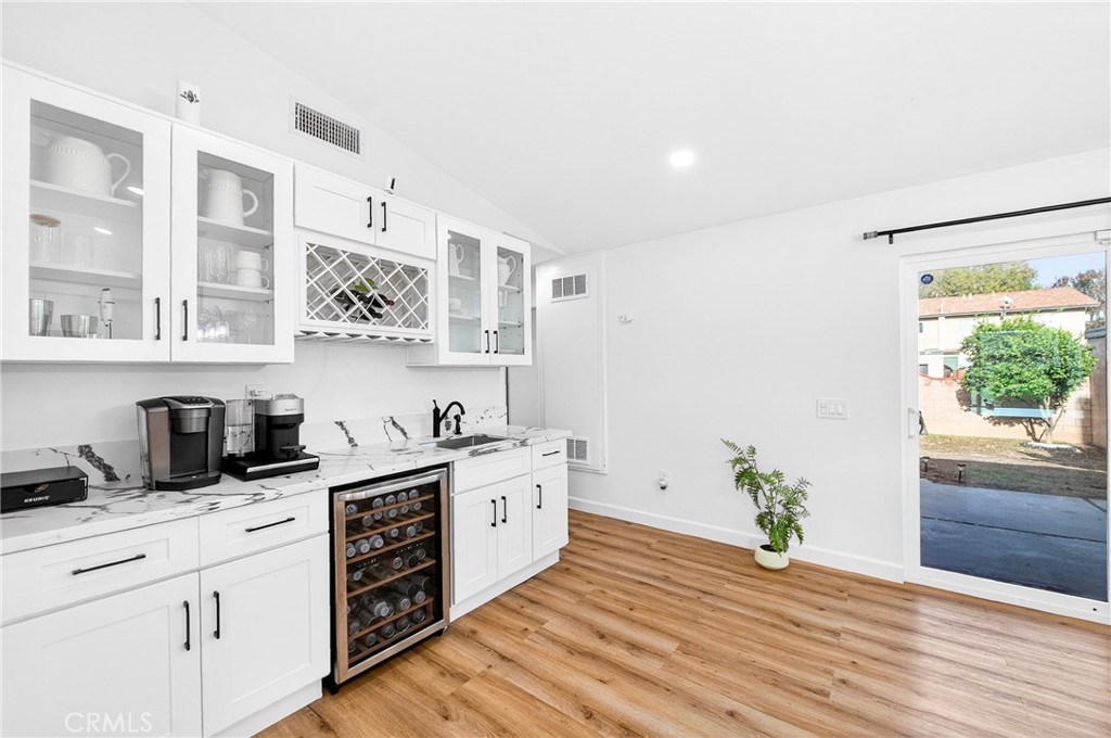 5050 Brooklawn Place Riverside, CA 92504 - Photo 11 of 44 a kitchen with stainless steel appliances white cabinets a stove a sink and wooden floor
