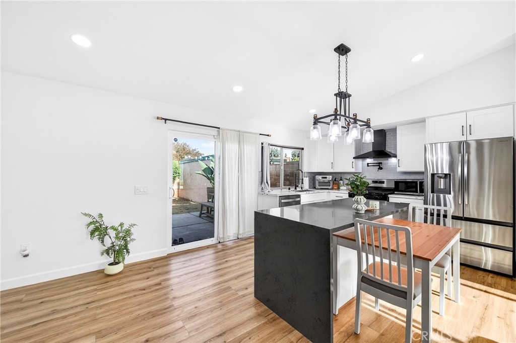 5050 Brooklawn Place Riverside, CA 92504 - Photo 14 of 44 a kitchen with stainless steel appliances a dining table chairs and refrigerator