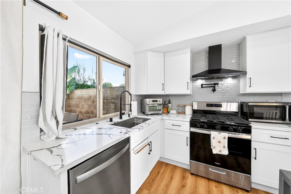 5050 Brooklawn Place Riverside, CA 92504 - Photo 15 of 44 a kitchen with a stove a sink and a microwave