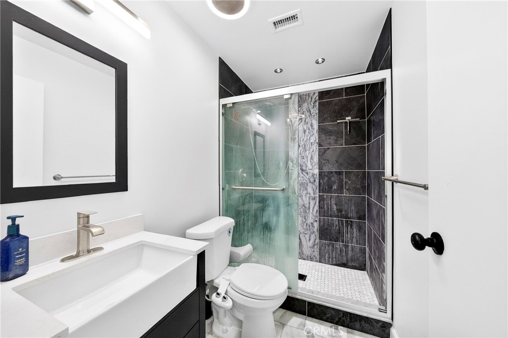 5050 Brooklawn Place Riverside, CA 92504 - Photo 24 of 44 a bathroom with a sink a toilet and shower