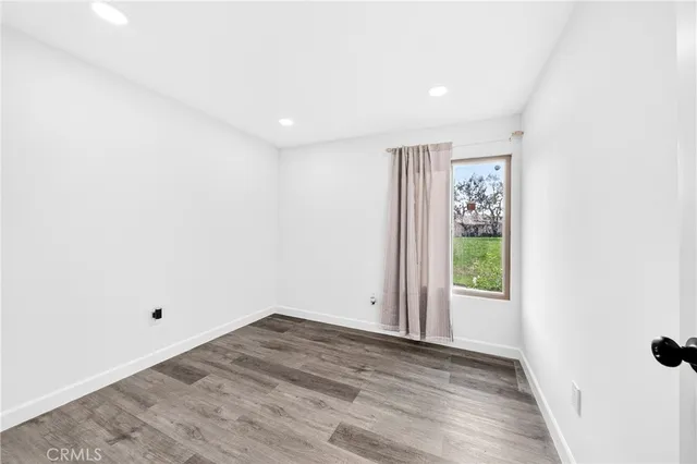 a view of a big room with wooden floor and windows