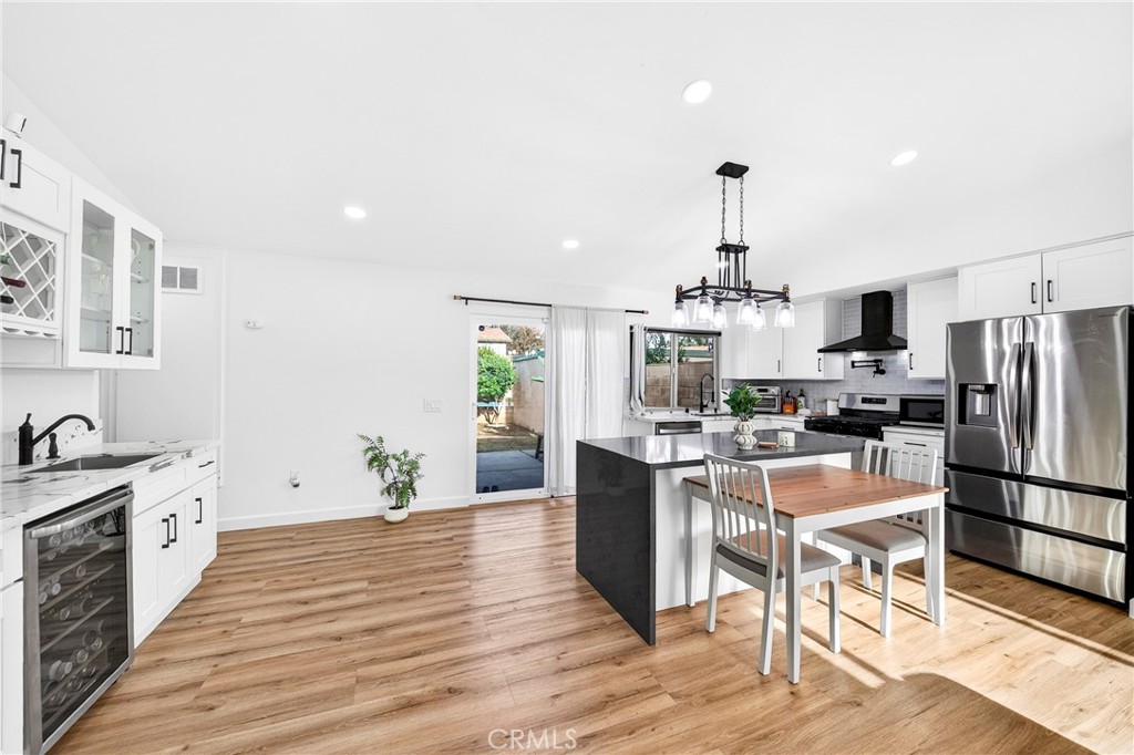 5050 Brooklawn Place Riverside, CA 92504 - Photo 8 of 44 a kitchen with granite countertop a refrigerator stove a oven and white cabinets with wooden floor