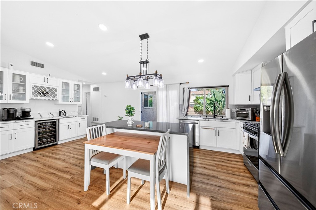 5050 Brooklawn Place Riverside, CA 92504 - Photo 10 of 44 a kitchen with stainless steel appliances a dining table chairs stove and refrigerator