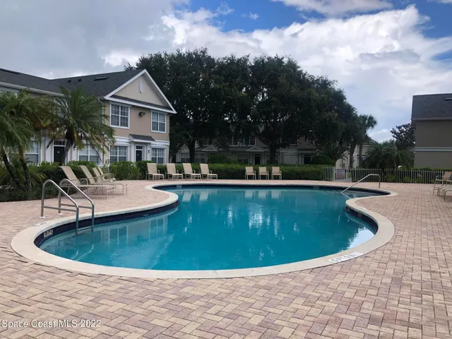 a view of a house with swimming pool and sitting area