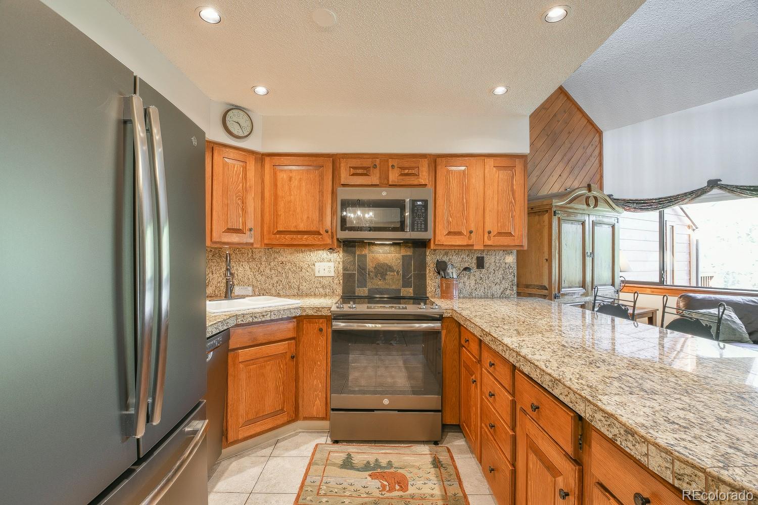 400 4 O Clock Road, Unit E Breckenridge, CO 80424 - Photo 13 of 34 a kitchen with stainless steel appliances granite countertop a sink stove and refrigerator