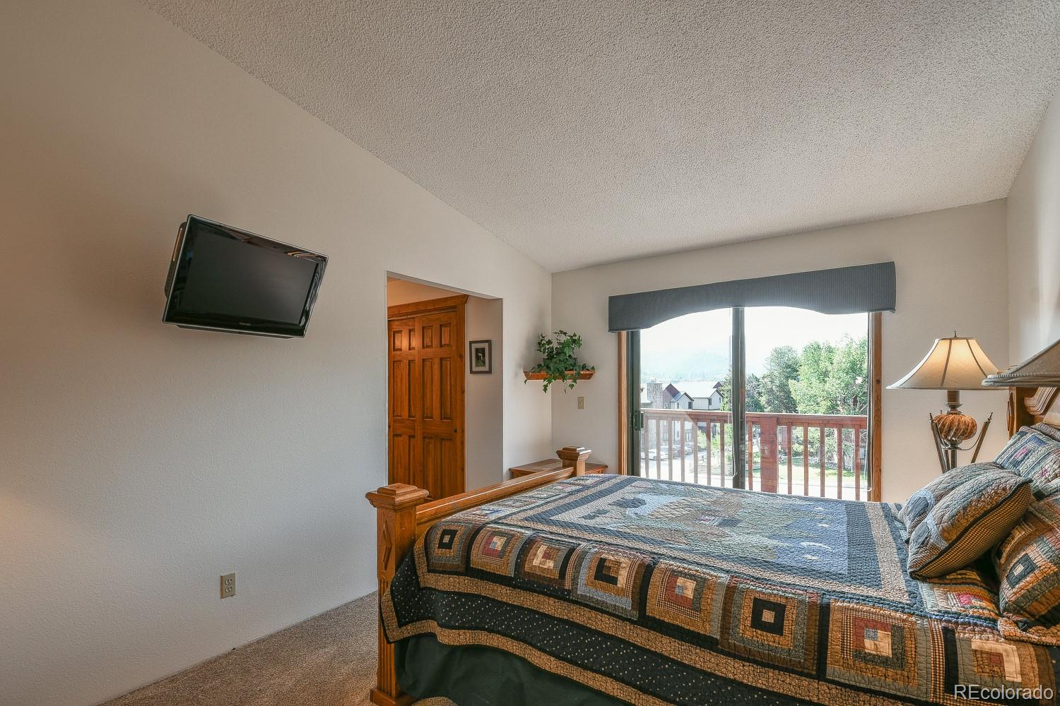 400 4 O Clock Road, Unit E Breckenridge, CO 80424 - Photo 19 of 34 a bedroom with a bed and a flat screen tv