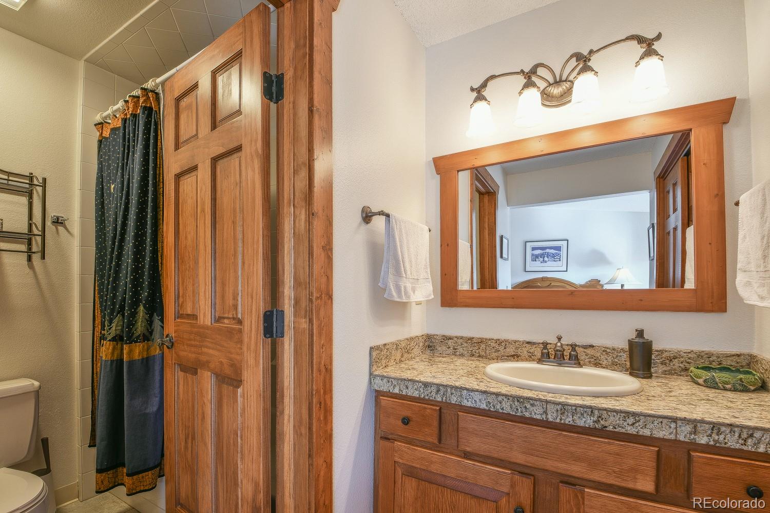 400 4 O Clock Road, Unit E Breckenridge, CO 80424 - Photo 21 of 34 a bathroom with a granite countertop sink vanity mirror and toilet