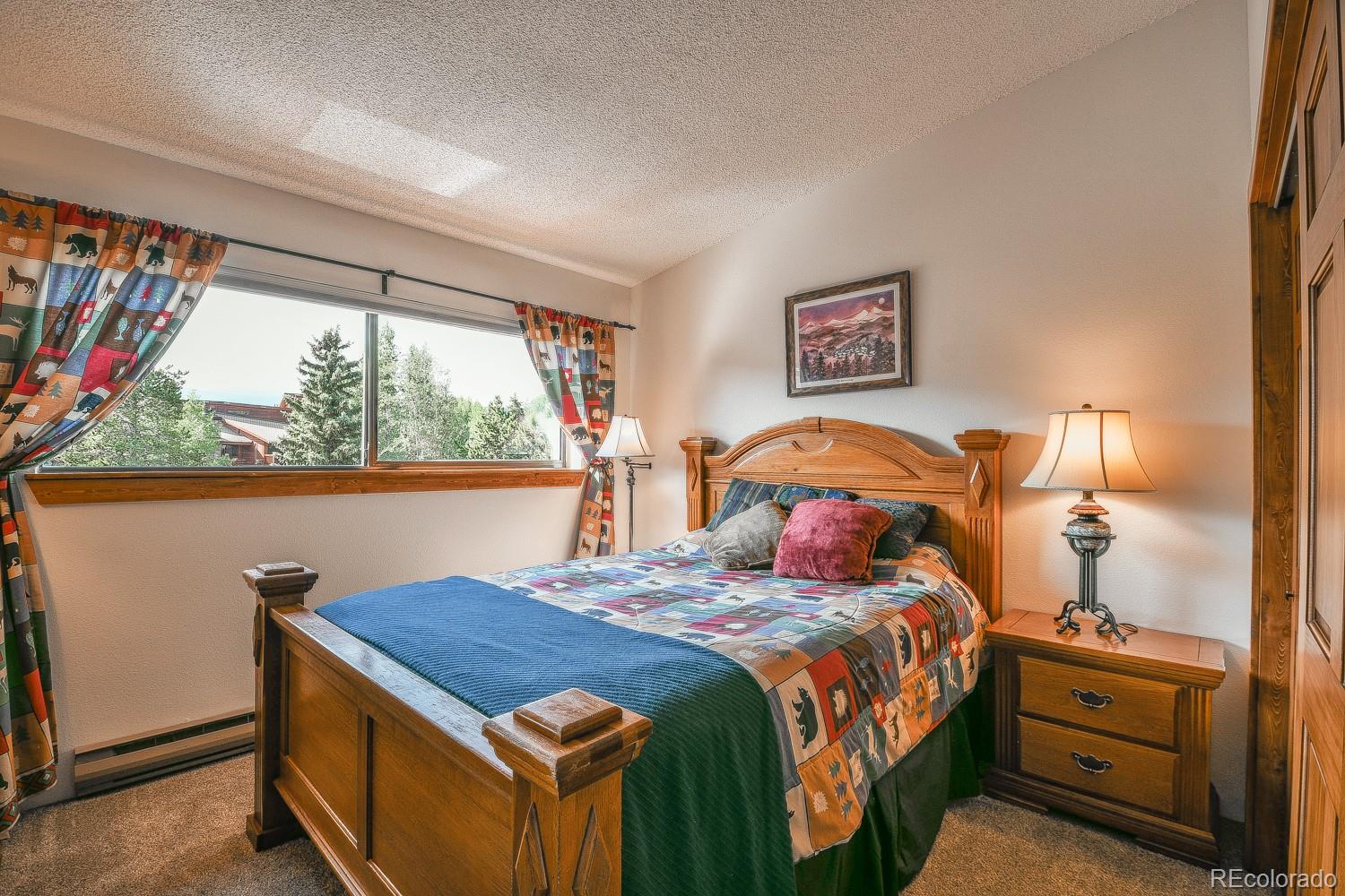 400 4 O Clock Road, Unit E Breckenridge, CO 80424 - Photo 22 of 34 a bedroom with a bed and a dresser next to a window