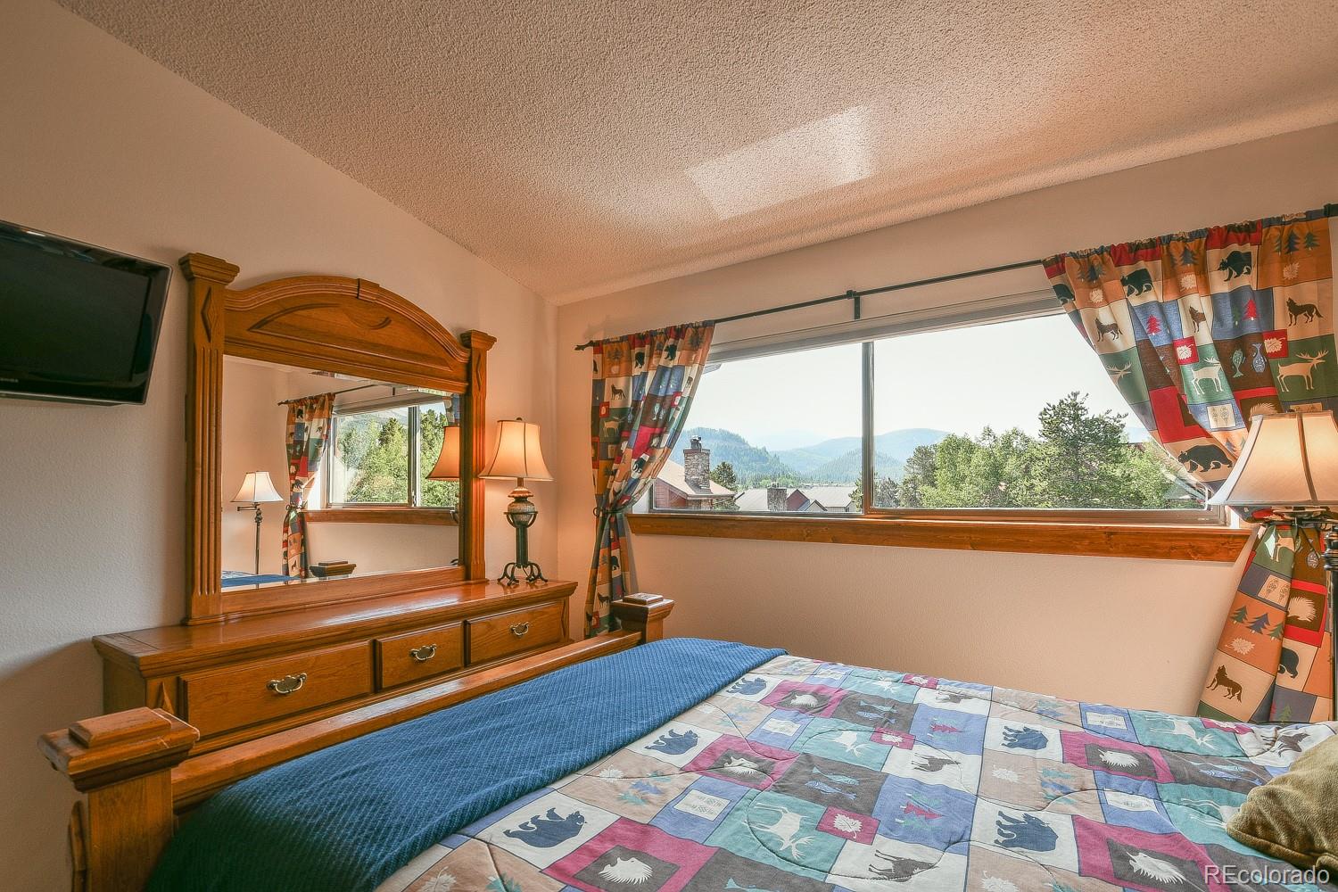 400 4 O Clock Road, Unit E Breckenridge, CO 80424 - Photo 23 of 34 a bedroom with a bed and wooden floor