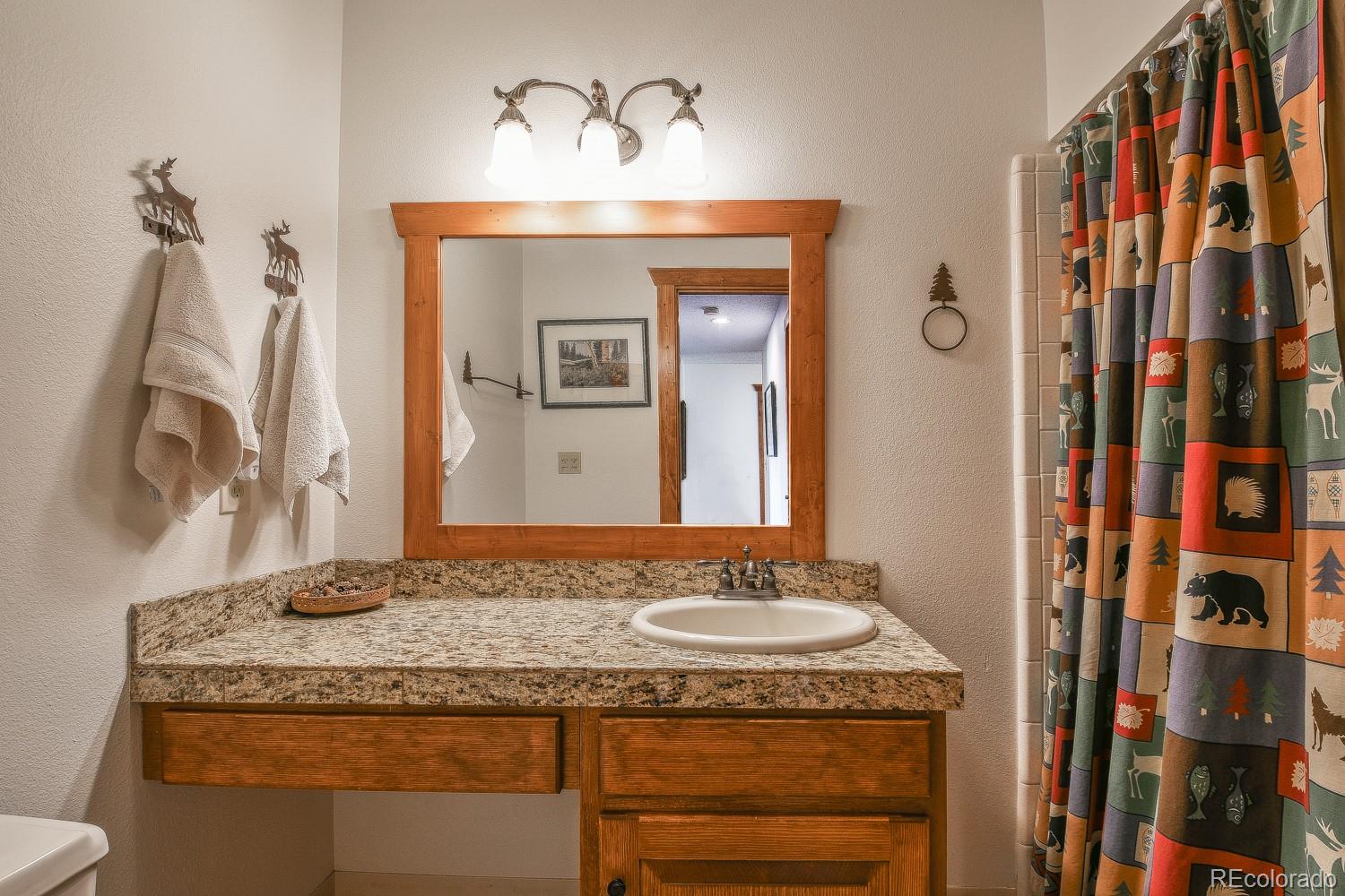 400 4 O Clock Road, Unit E Breckenridge, CO 80424 - Photo 24 of 34 a bathroom with a granite countertop sink and a mirror