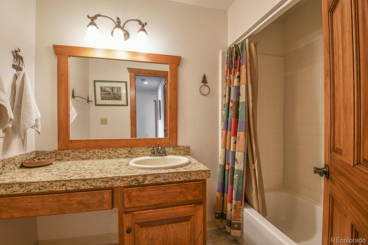 400 4 O Clock Road, Unit E Breckenridge, CO 80424 - Photo 25 of 34 a bathroom with a granite countertop sink and a mirror
