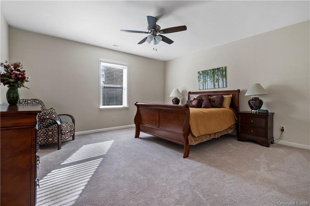 5318 Meadowcroft Way Fort Mill, SC 29708 - Photo 29 of 48 a bedroom with a bed and a chandelier