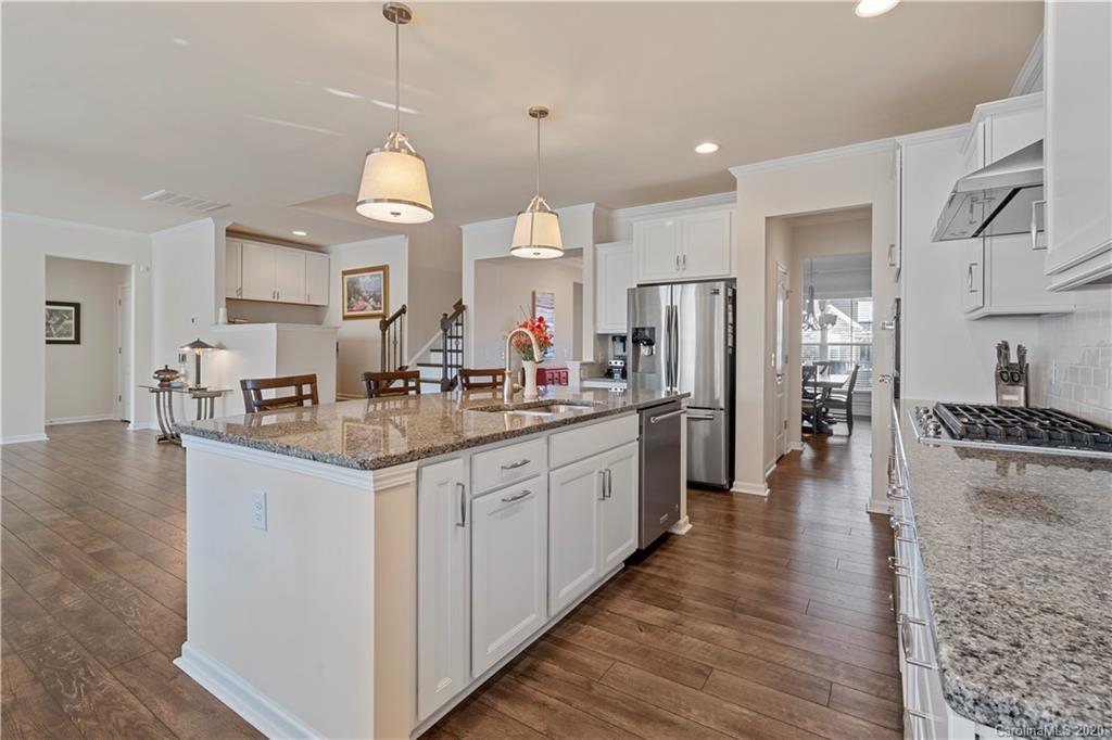 5318 Meadowcroft Way Fort Mill, SC 29708 - Photo 5 of 48 a kitchen with stainless steel appliances granite countertop a refrigerator a sink dishwasher a oven and a dining table with wooden floor