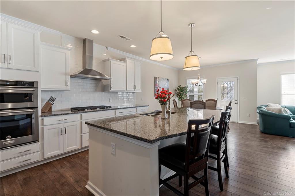 5318 Meadowcroft Way Fort Mill, SC 29708 - Photo 6 of 48 a kitchen with a dining table cabinets and stainless steel appliances