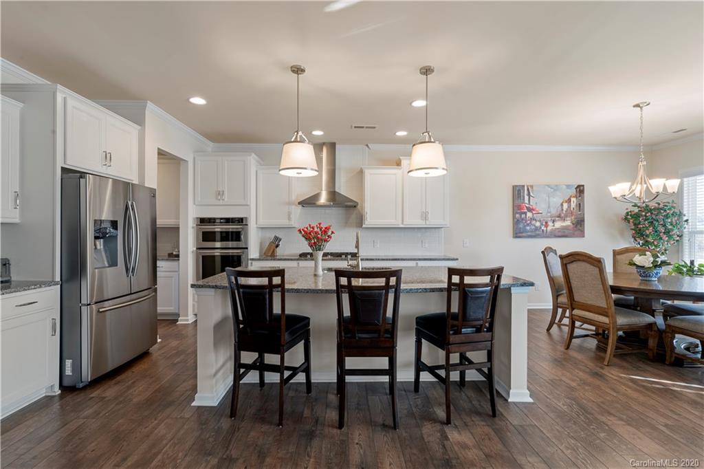 5318 Meadowcroft Way Fort Mill, SC 29708 - Photo 10 of 48 a kitchen with stainless steel appliances kitchen island granite countertop a dining table chairs and a refrigerator