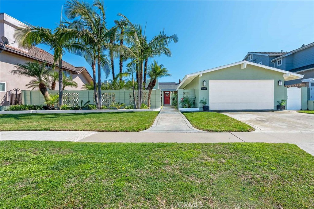 a view of a house with a yard and palm trees