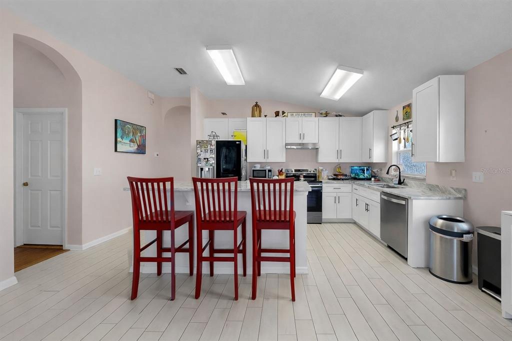 2310 Potomac Mark Place Ruskin, FL 33570 - Photo 8 of 40 a open kitchen with stainless steel appliances a dining table chairs and wooden floor