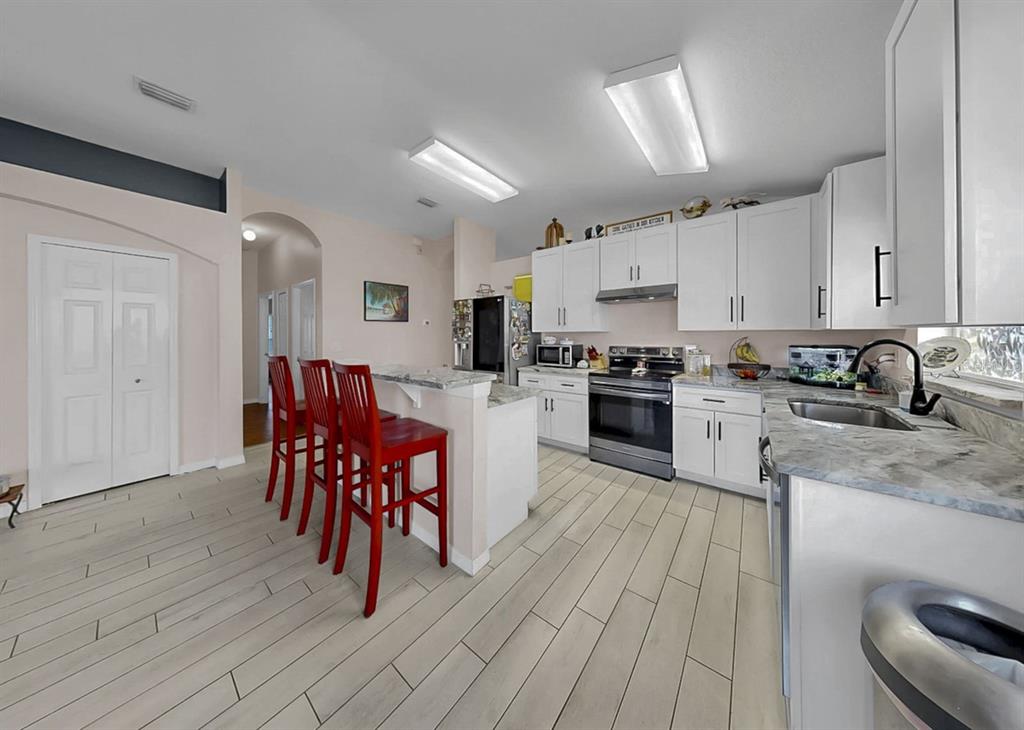 2310 Potomac Mark Place Ruskin, FL 33570 - Photo 10 of 40 a kitchen with granite countertop a sink cabinets and wooden floor