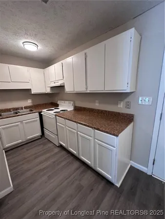 a kitchen with granite countertop a sink cabinets and stainless steel appliances