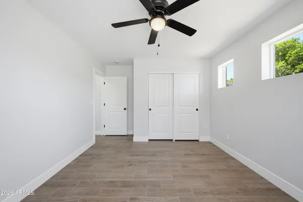 an empty room with a ceiling fan and shower