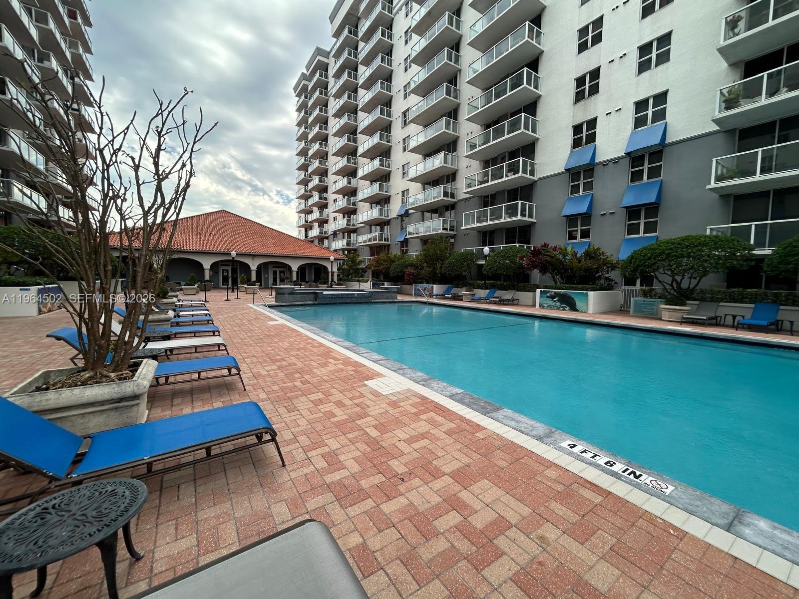 5077 Northwest 7th Street, Unit 1012 Miami, FL 33126 - Photo 13 of 15 a swimming pool with outdoor seating and yard