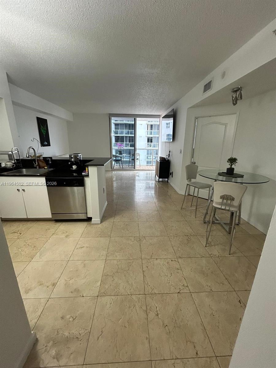 5077 Northwest 7th Street, Unit 1012 Miami, FL 33126 - Photo 6 of 15 a kitchen with a sink and a stove top oven