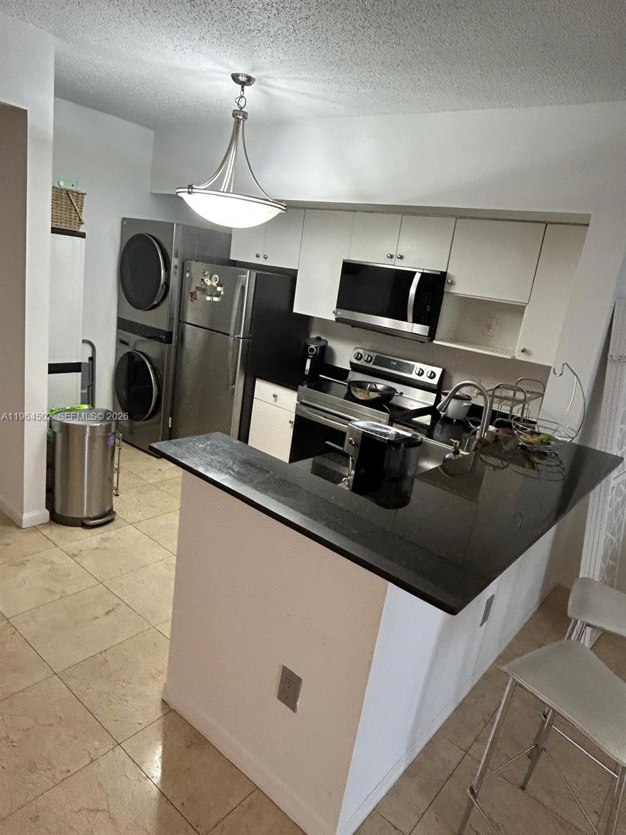 5077 Northwest 7th Street, Unit 1012 Miami, FL 33126 - Photo 8 of 15 a kitchen with a stove and a refrigerator
