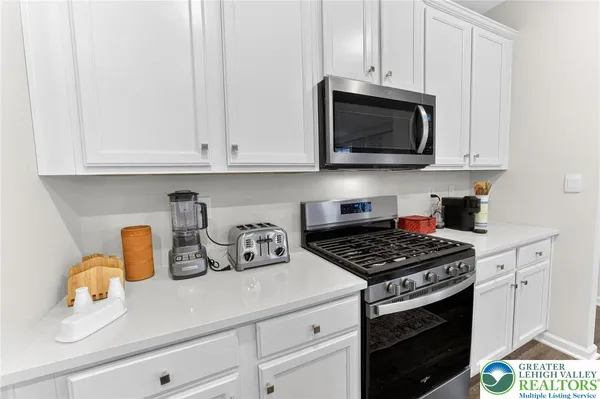 a kitchen with white cabinets and a stove top oven