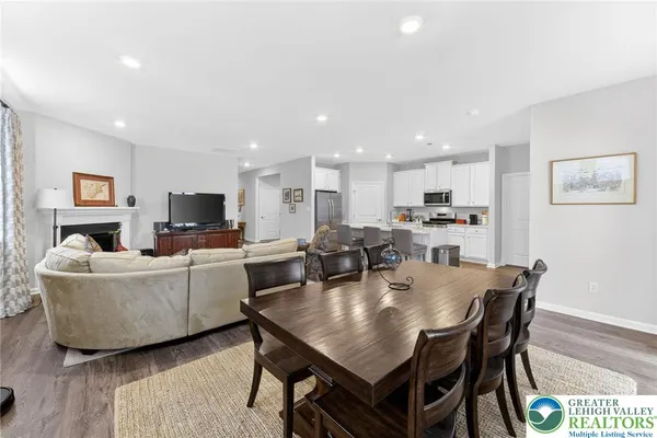 a living room with furniture a flat screen tv and kitchen view