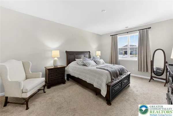 a bedroom with a bed couch and a window