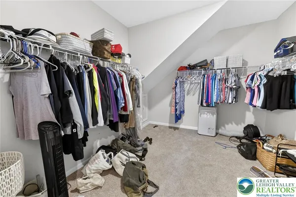 a view of walk in closet with clothes and shoes