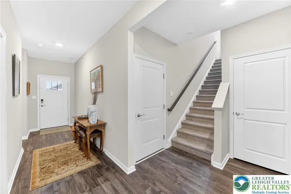 a view of a hallway with wooden floor and stairs