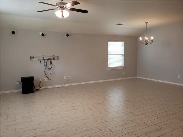 an empty room with windows and fan
