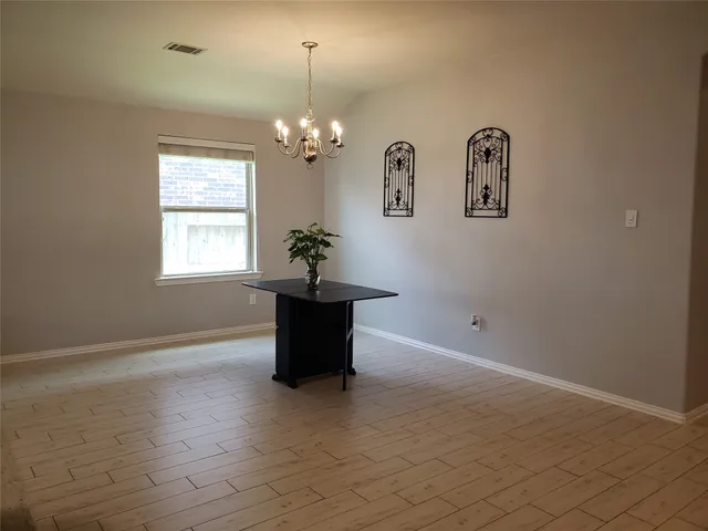 an empty room with windows and chandelier