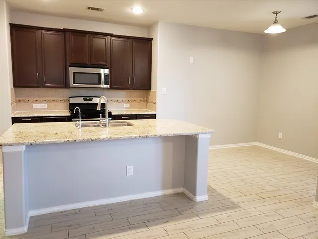a kitchen with stainless steel appliances granite countertop a sink microwave and stove